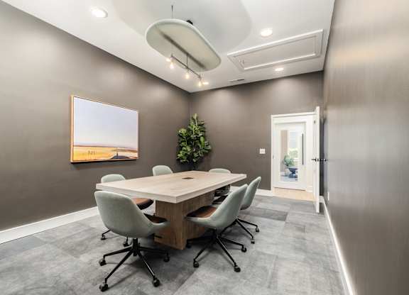 A conference room with a long table and chairs.