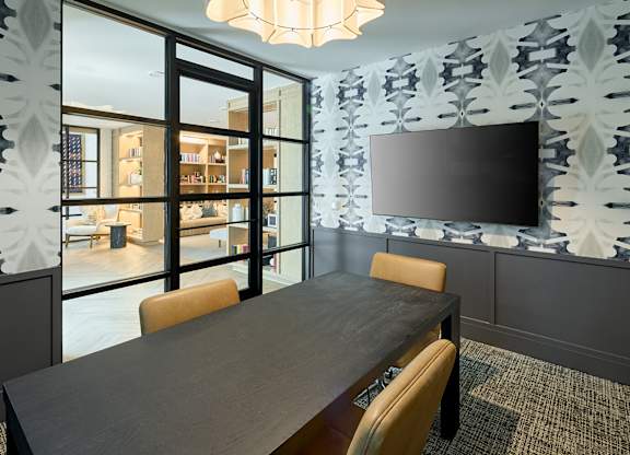 A modern dining room with a large table and chairs.