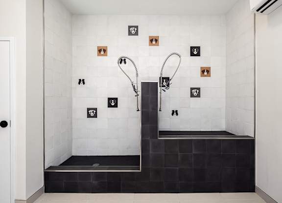 A modern bathroom with a walk-in shower and a black bench seat.