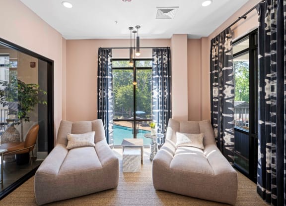 a living room with a couch and a chair in front of a pool