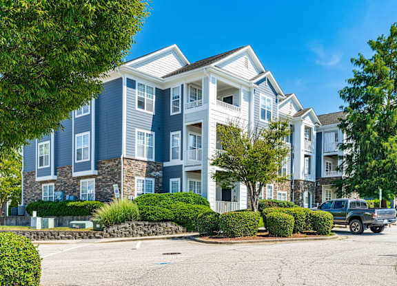 A large apartment building with a parking lot in front.