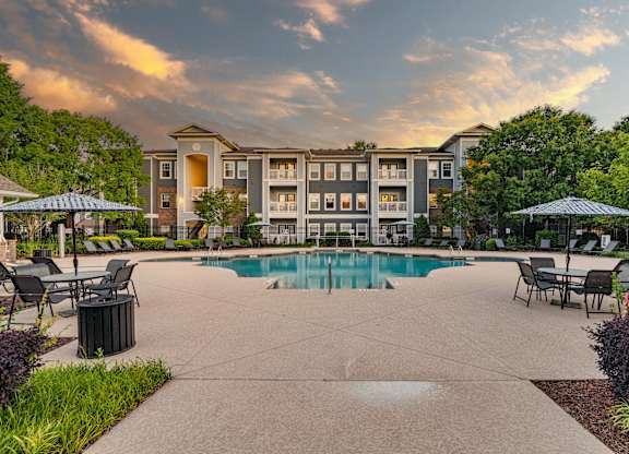 A large building with a pool in front of it.