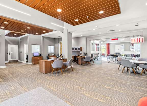 A spacious office with a variety of furniture and a wooden ceiling.