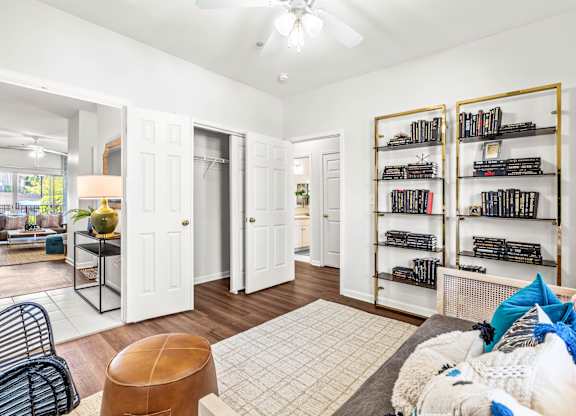 A living room with a brown leather ottoman and a white rug.