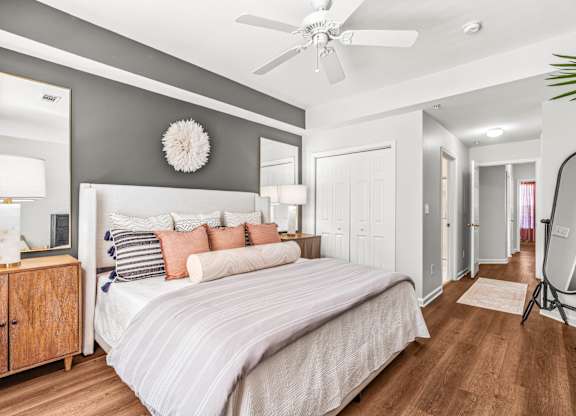 A bedroom with a large bed and a ceiling fan.