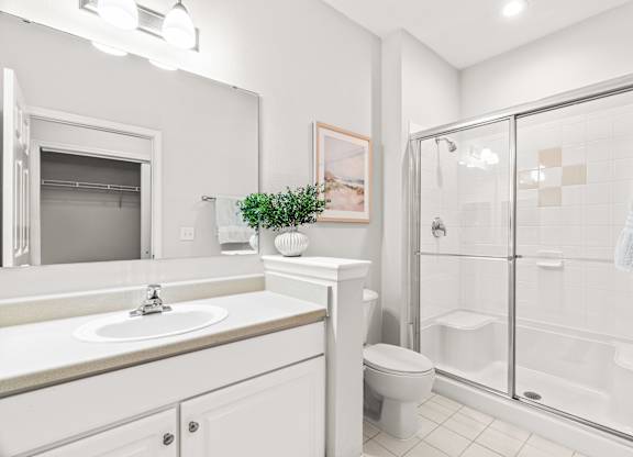 A white bathroom with a glass shower stall.