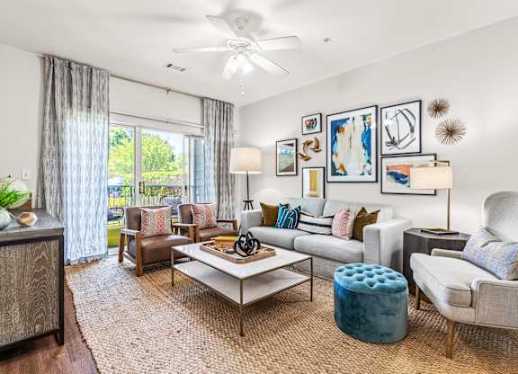 A living room with a white ceiling fan and a variety of furniture.