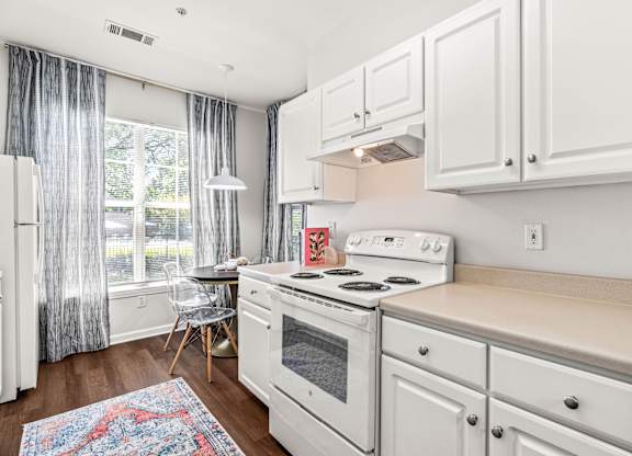 A white kitchen with a white stove and white cabinets.