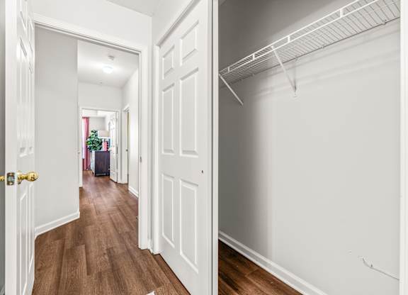 A hallway with a white door and a white wall.