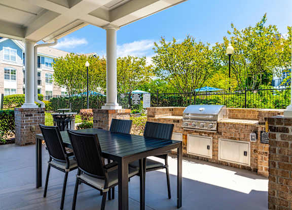 A patio with a table and chairs under a white roof.