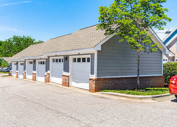 A building with a grey roof and white garage doors.