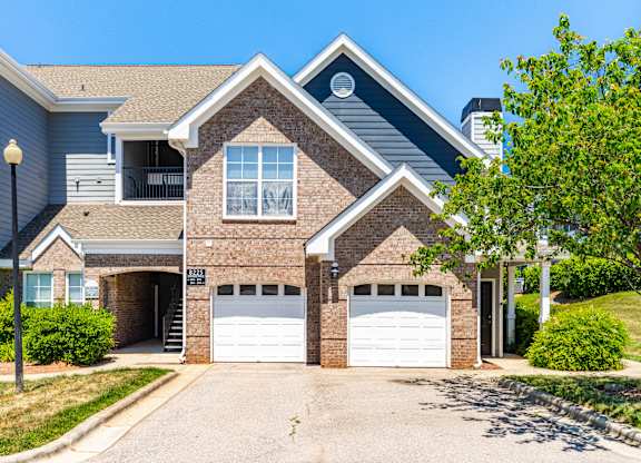 A two-story house with a garage and a driveway.
