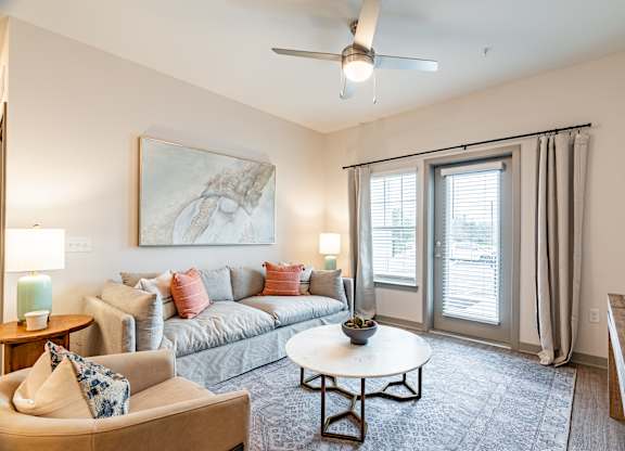 a living room with a couch coffee table and sliding glass doors