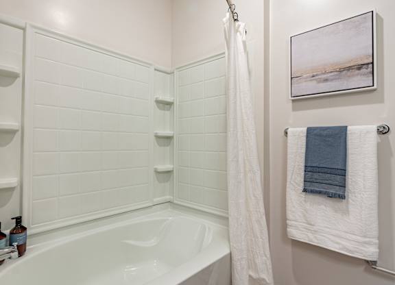 a bathroom with a white bathtub and a white shower curtain