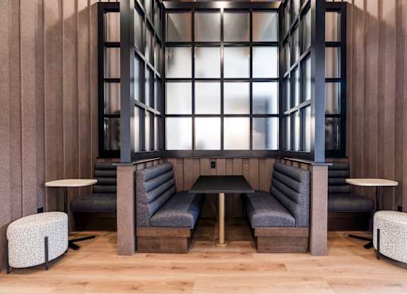 A modern lounge area with grey and black furniture.
