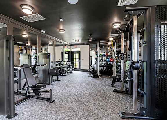 A gym with a variety of equipment including weights and machines.