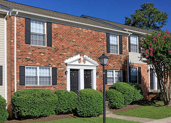 A brick house with a black door and windows.