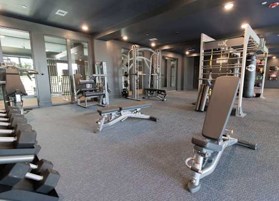 a gym with weights and other equipment in a building with glass doors