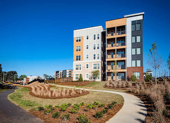 A modern apartment building with a curved walkway in front.