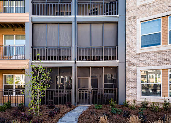 A modern apartment building with a walkway in front.