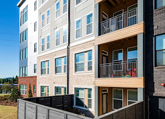 an apartment building with a wooden fence in front of it