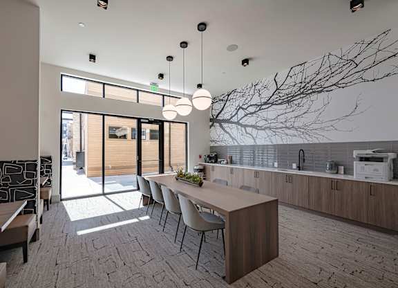a kitchen and dining area with a tree mural on the wall
