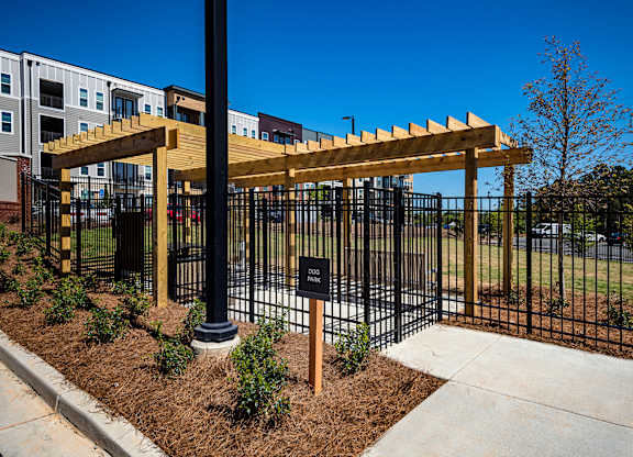 A black fence with a wooden gate and pillars.