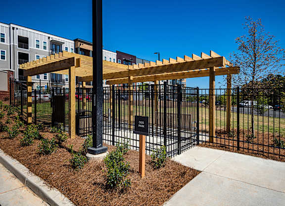 a black fence with a wooden pergola in front of a building