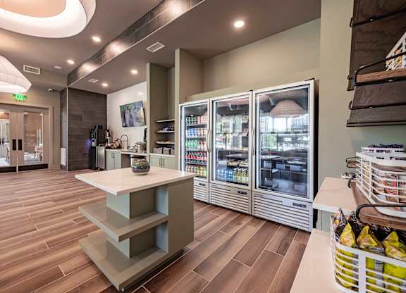 a room with a fridge and a table with a vase on it