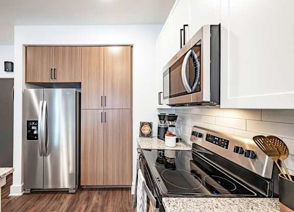 a kitchen with white cabinets and stainless steel appliances