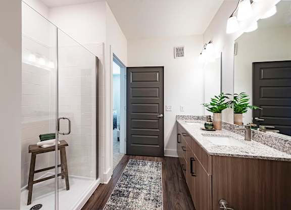 a bathroom with a large mirror and a shower with a glass door