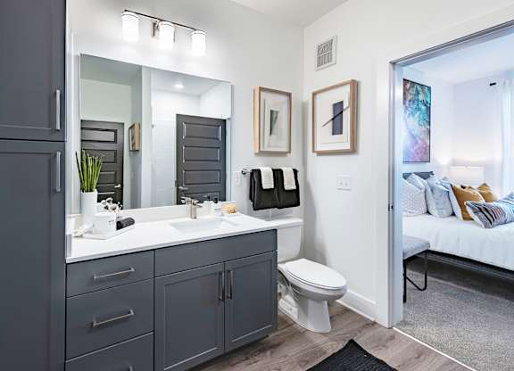 a bathroom with gray cabinets and a white countertop
