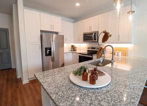 a kitchen with white cabinets and a granite counter top