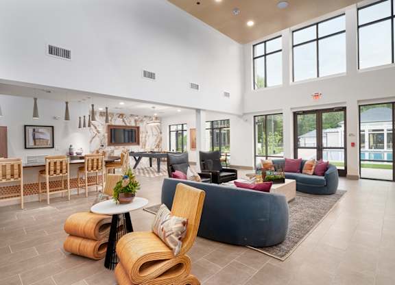 A spacious living room with a variety of seating options and a view of the outdoors.