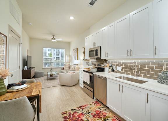 A kitchen with white cabinets and a tiled backsplash.