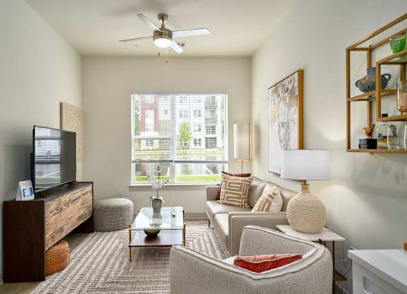A living room with a couch, armchair, and television.