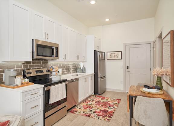 A kitchen with white cabinets and a black stove top oven.
