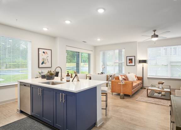 A modern kitchen with blue cabinets and a white countertop.