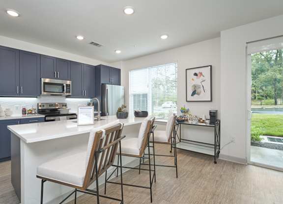 A kitchen with a white countertop and blue cabinets.