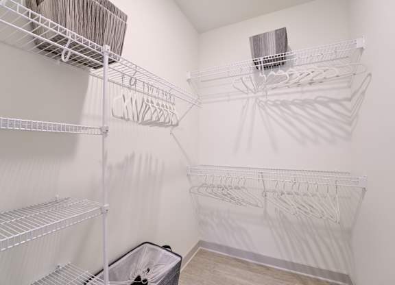 A white laundry room with a washer and dryer on the wall.