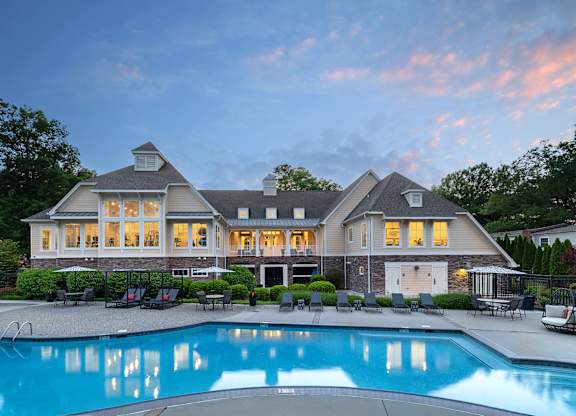 A large house with a pool in front.