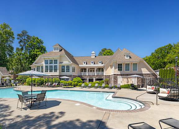 A large house with a pool in front.