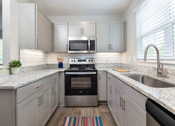 A modern kitchen with a stove and microwave built into the cabinetry.
