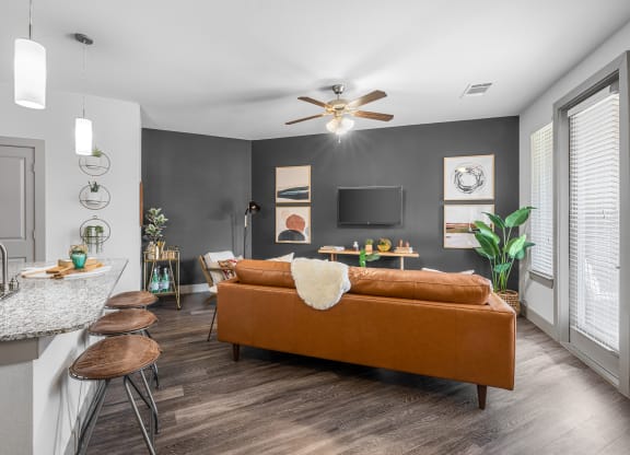 breakfast bar area overlooking living area with sofa, tv and art on the walls