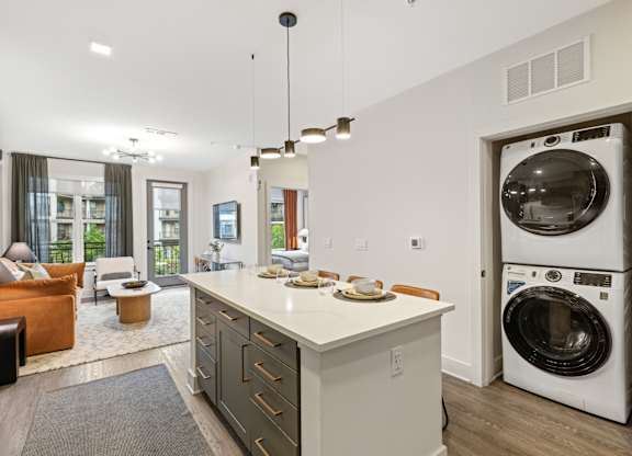 A modern kitchen with a washing machine in the door.