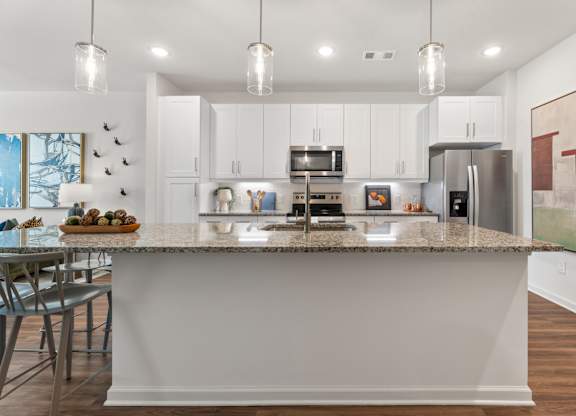 A kitchen with a granite countertop and stainless steel appliances.