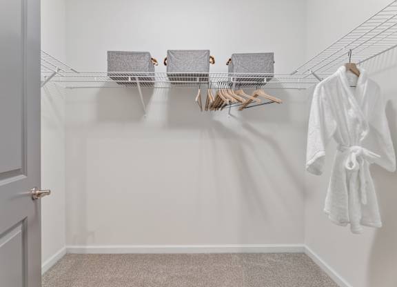 A white bathroom with a towel hanging on the wall.