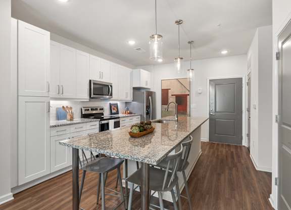 A kitchen with a table and chairs in the middle of it.