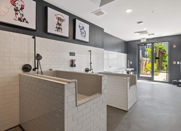 A bathroom with a white tiled wall and a white sink.