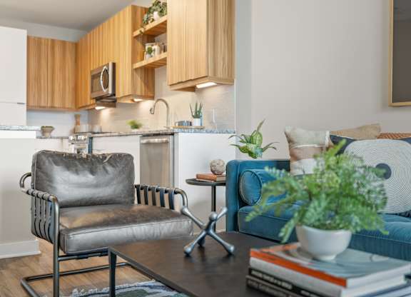 A modern kitchen with a grey chair and a blue couch.